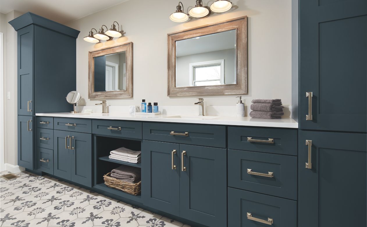 bathrooom vanity with two sinks, mirrors, and stylish blue cabinetry 